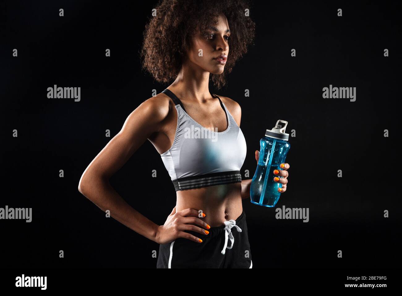Image of beautiful african american sportswoman holding water bottle ...