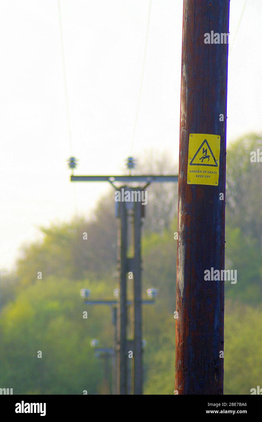 Telegraph pole with a danger warning sign Stock Photo