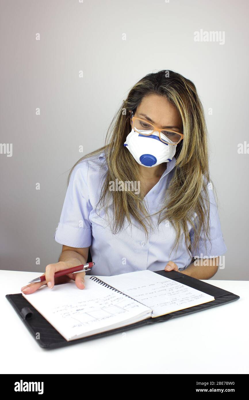 Beautiful business woman working with a surgical mask Stock Photo