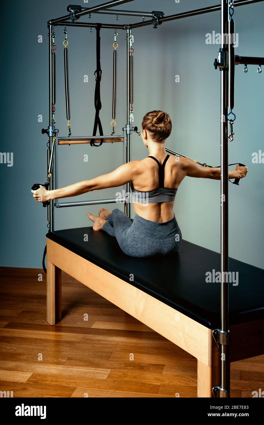 Gymnast woman pilates stretching sport in reformer bed instructor girl