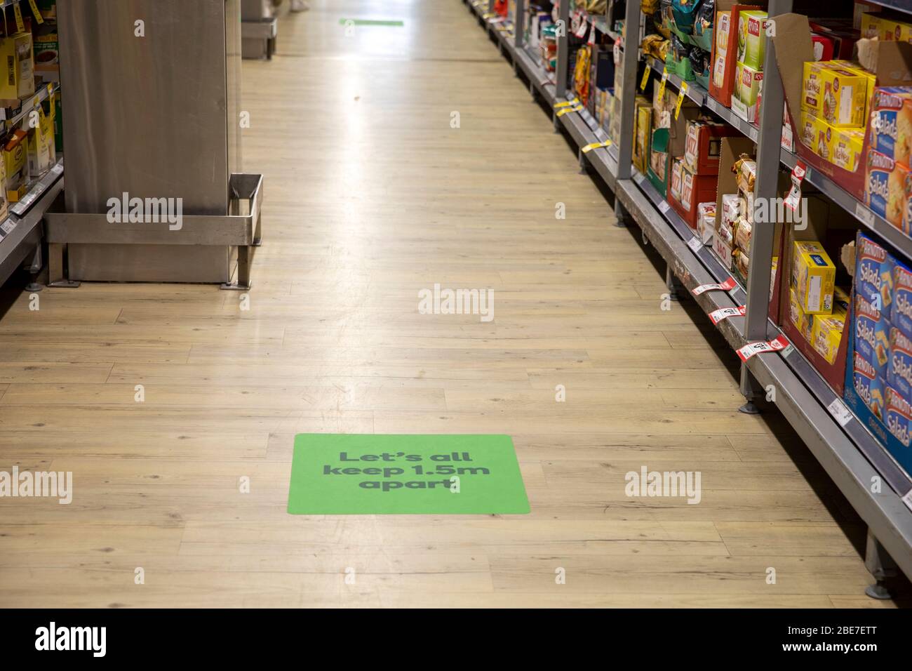 Social distancing reinforced in australian supermarket with floor sign saying lets all keep 1.5m apart Stock Photo