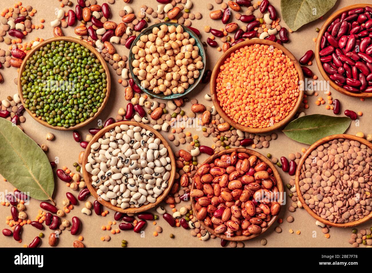 Legumes assortment, shot from above on a brown background. Lentils, soybeans, chickpeas, red kidney beans, a vatiety of pulses Stock Photo