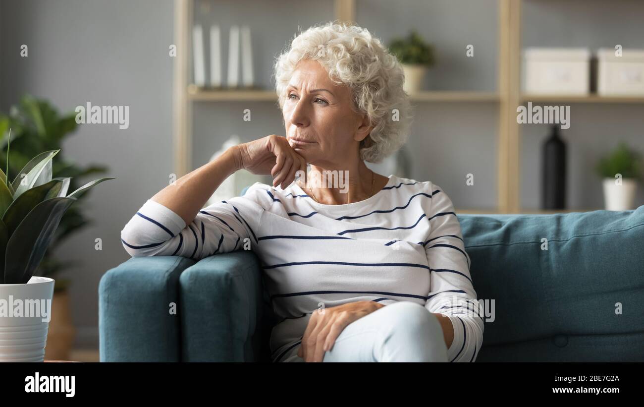 Mature woman sitting on couch hi-res stock photography and images - Alamy