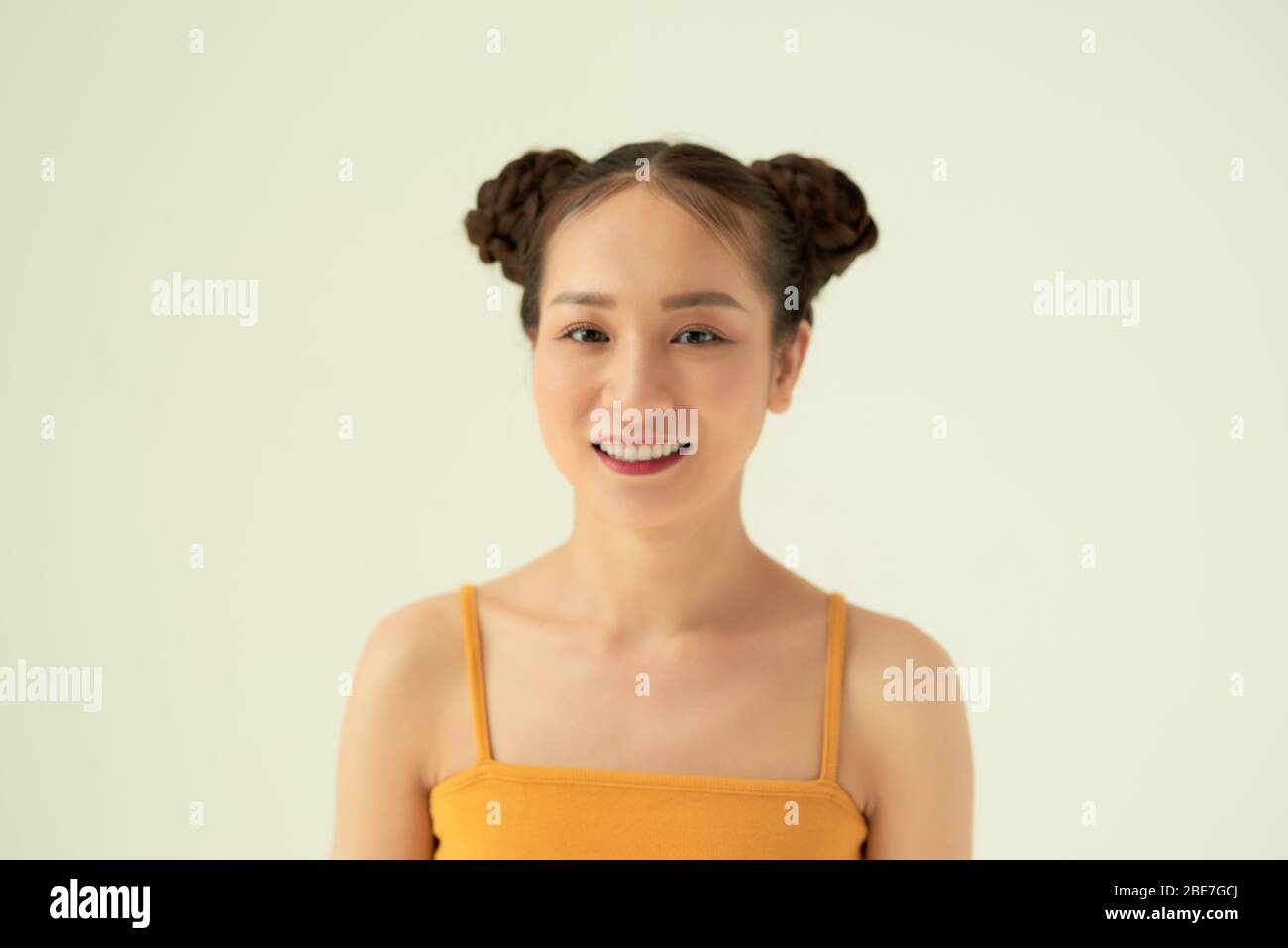 Young cheerful happy ginger girl with buns and freckles smiling looking