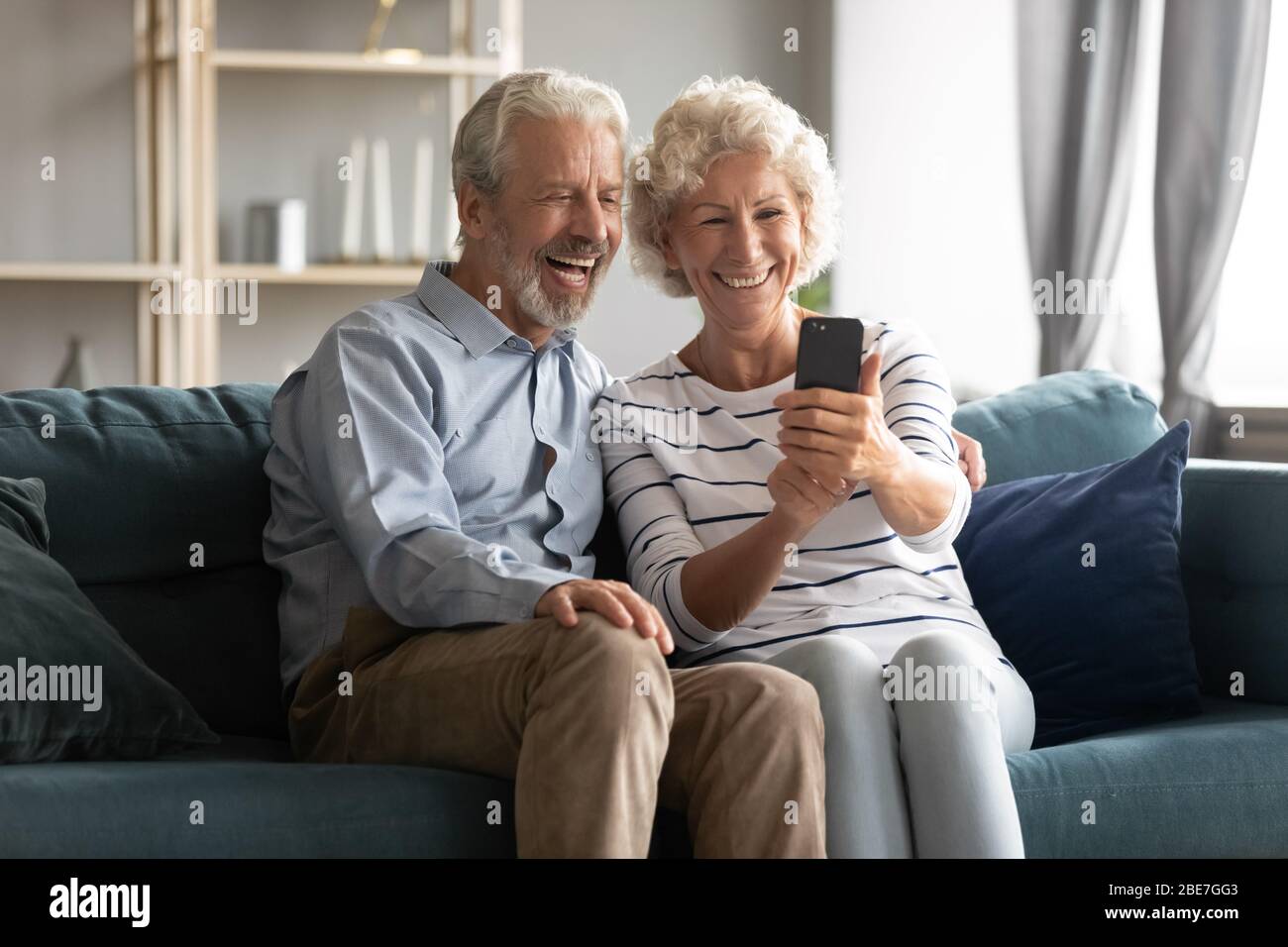 Excited mature couple having fun with phone together Stock Photo