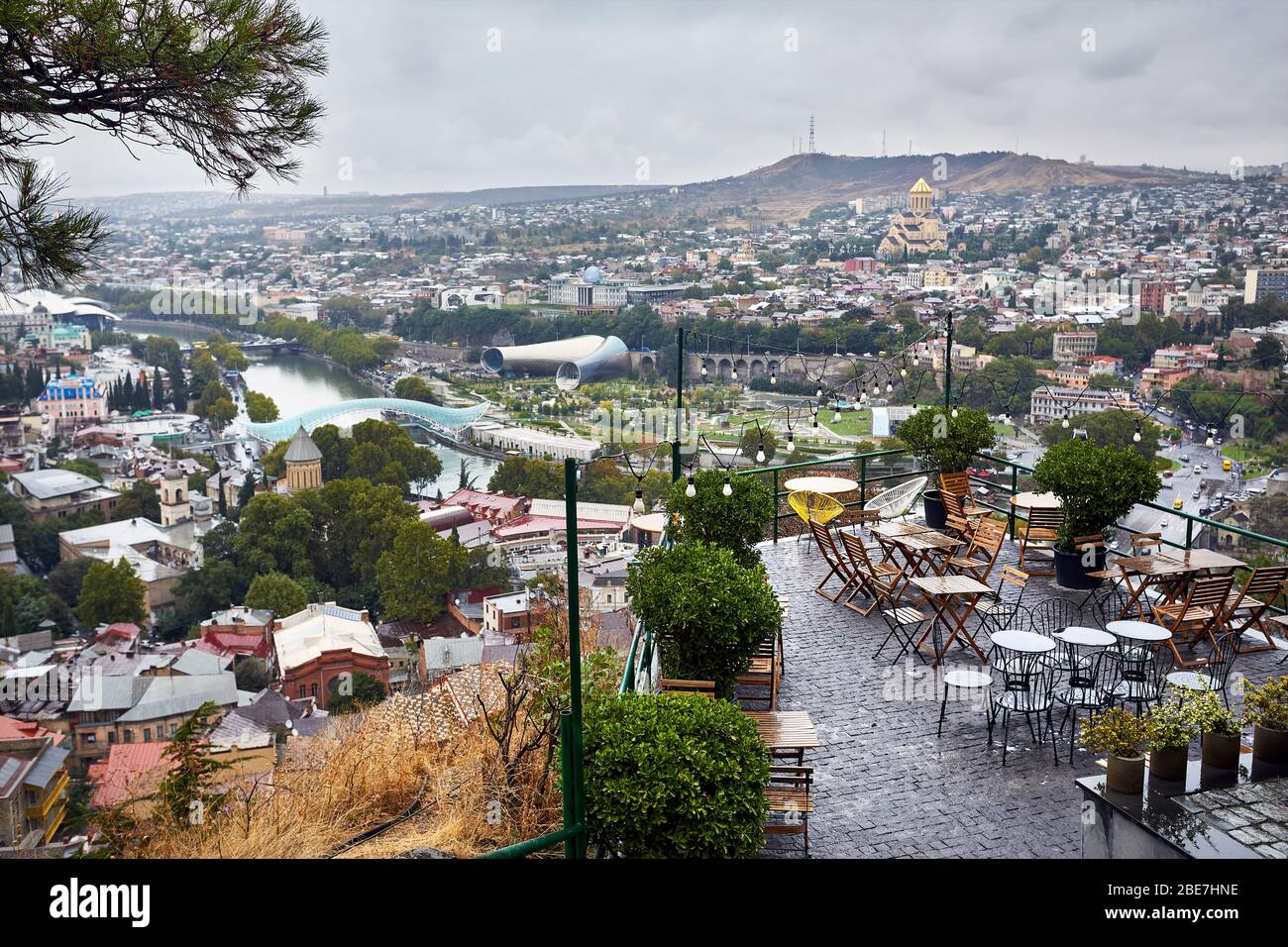 Empty cafe at Narikala Fortress with panoramic view Tbilisi at overcast sky, Georgia Stock Photo