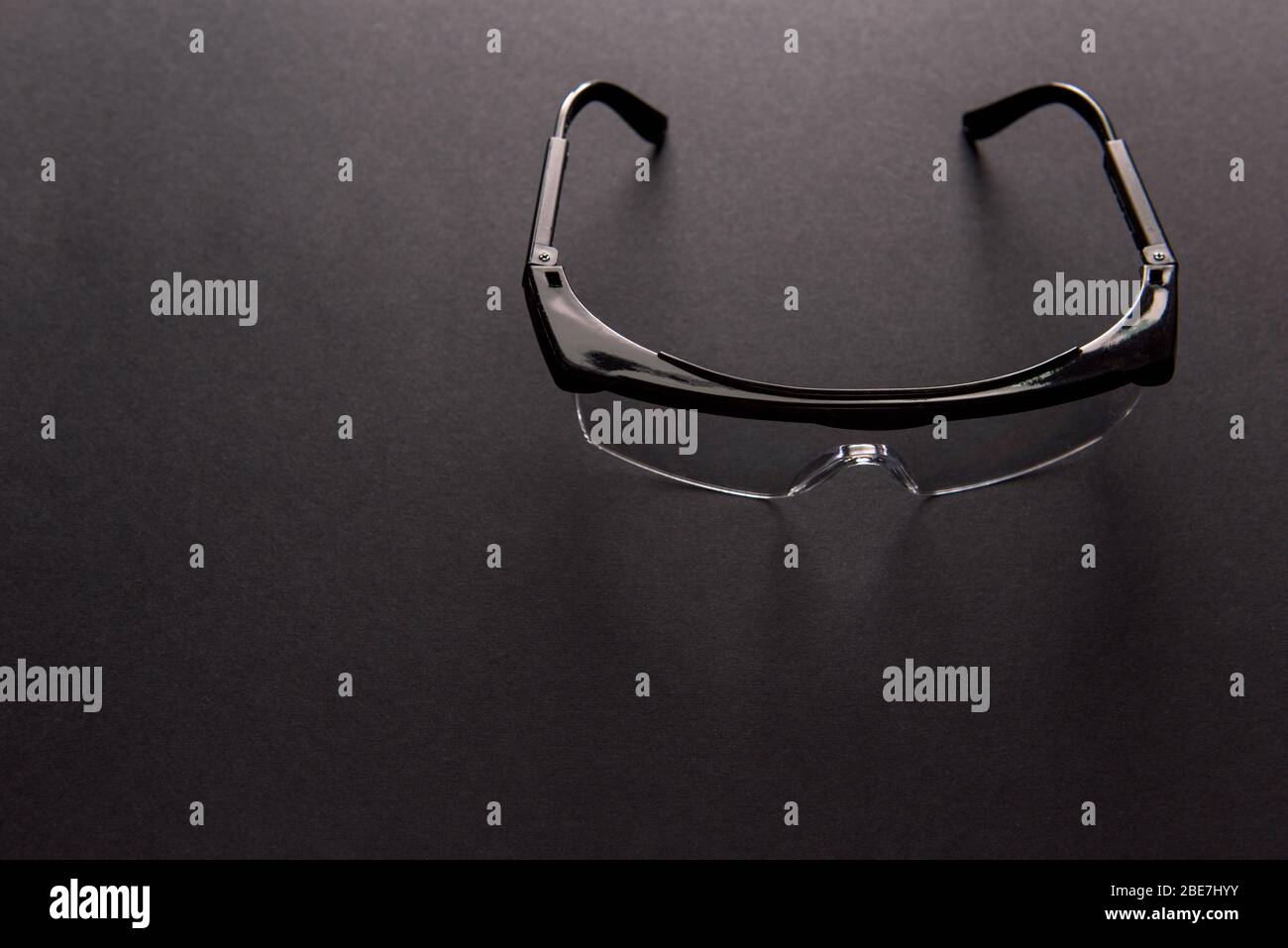 Transparent safety goggles on dark gray background Stock Photo