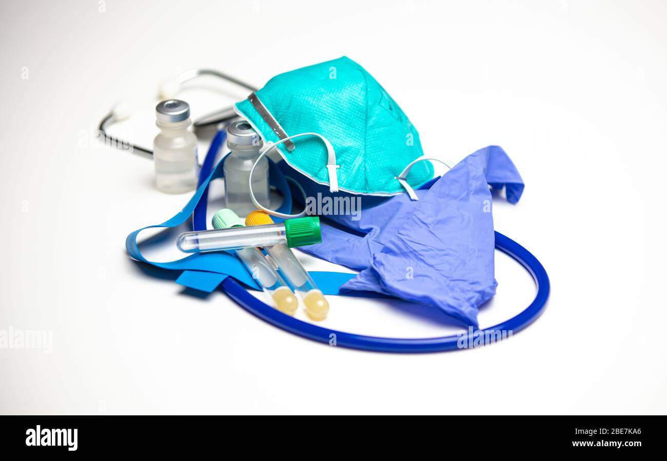 Assorted medical supplies. Respirator mask on top of gloves. Empty blood collection tubes Stock