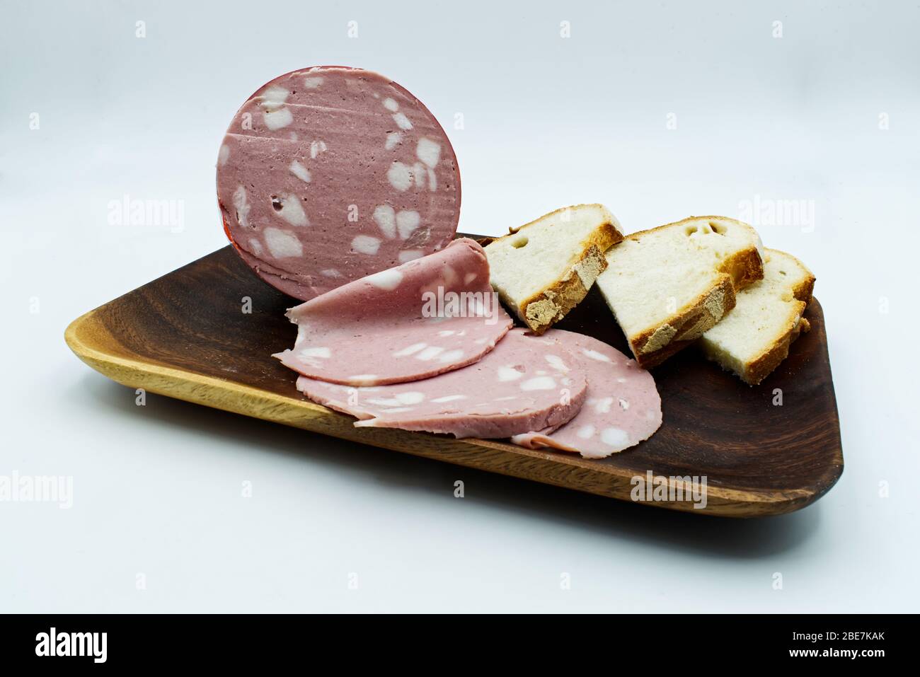 Italian Mortadella bolognese with slices of bread. Pork salami Mortadella isolated on white