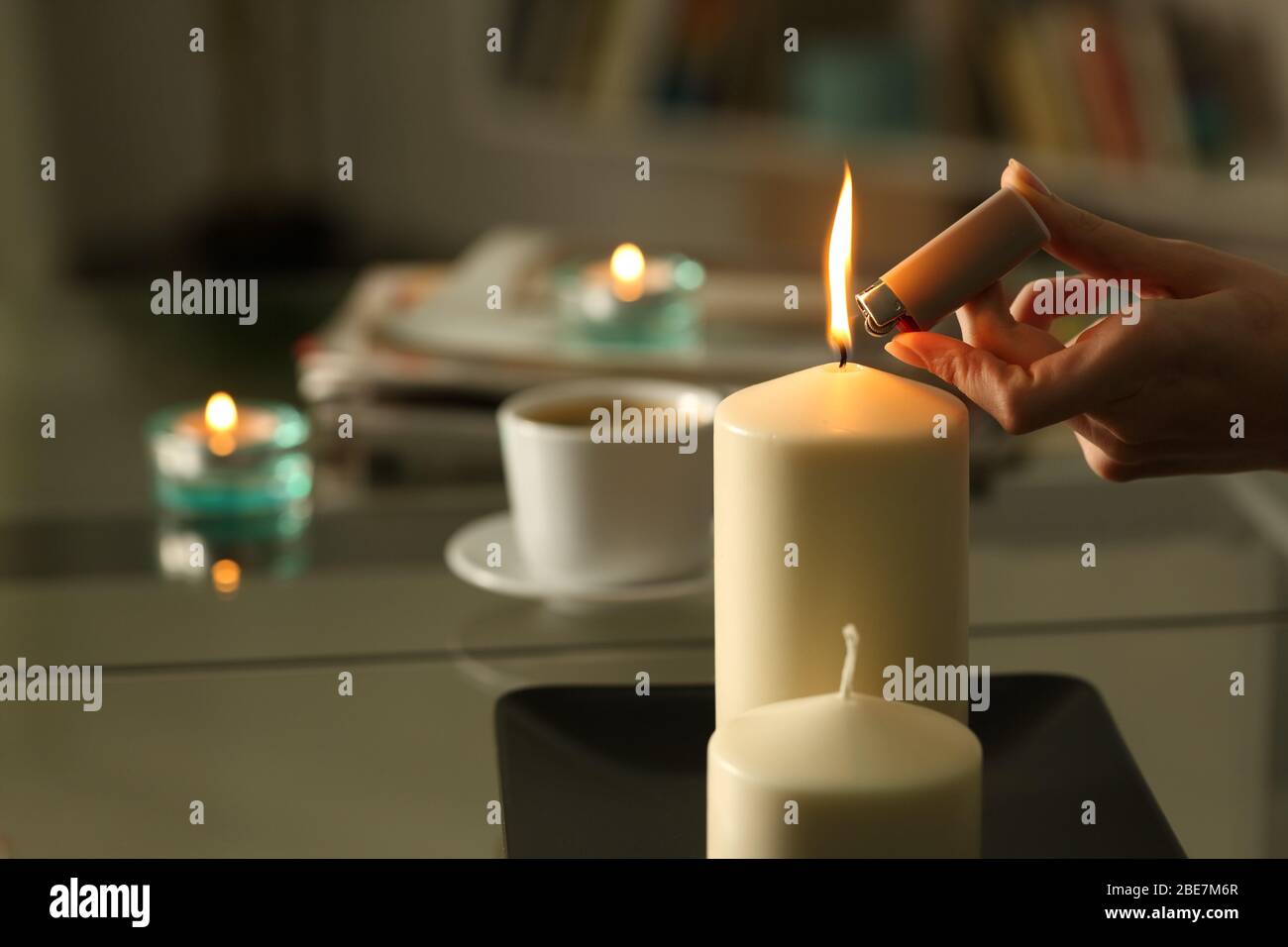 https://c8.alamy.com/comp/2BE7M6R/close-up-of-woman-hand-lighting-candles-with-lighter-in-the-night-at-home-on-a-power-outage-2BE7M6R.jpg