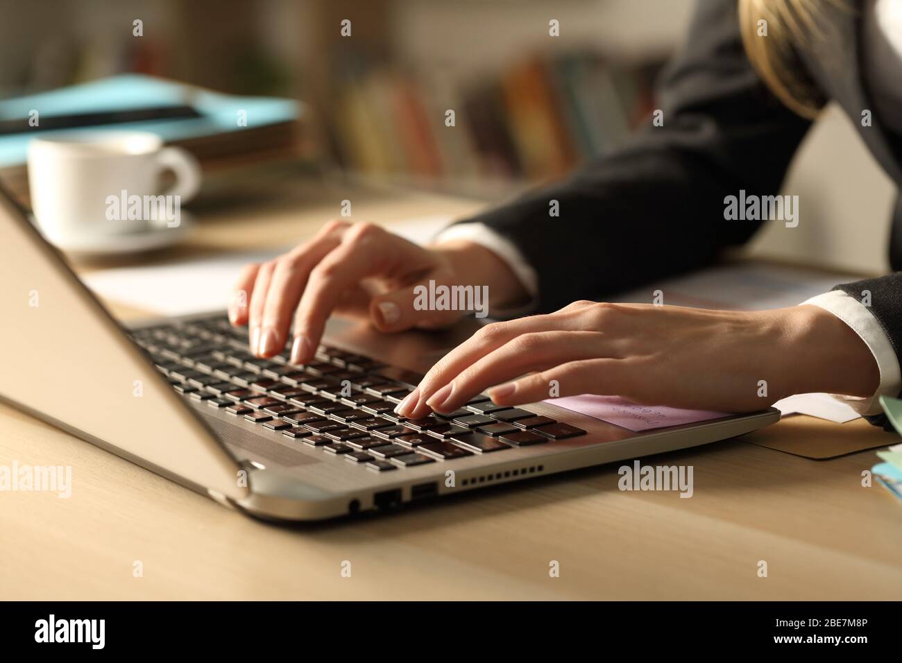 Close up of entrepreneur woman hands typing on laptop at night on a desk Stock Photo