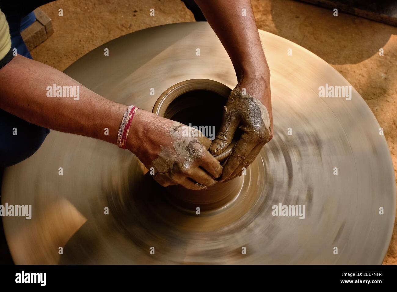 Pottery - skilled wet hands of potter shaping the clay on potter wheel Stock Photo