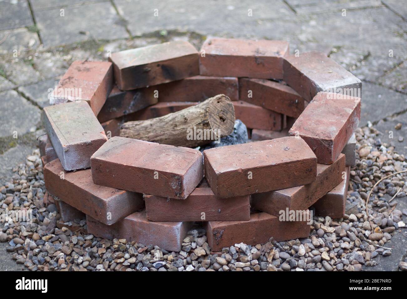 Home made brick built fire pit or barbecue with logs Stock Photo