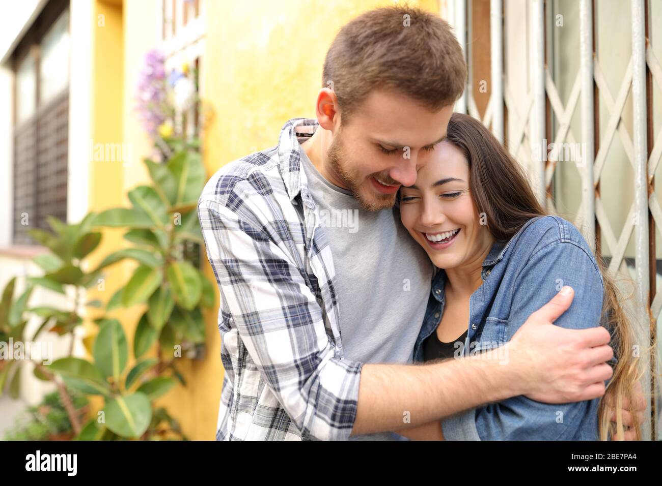 Happy young couple in love flirting and hugging in the street Stock Photo