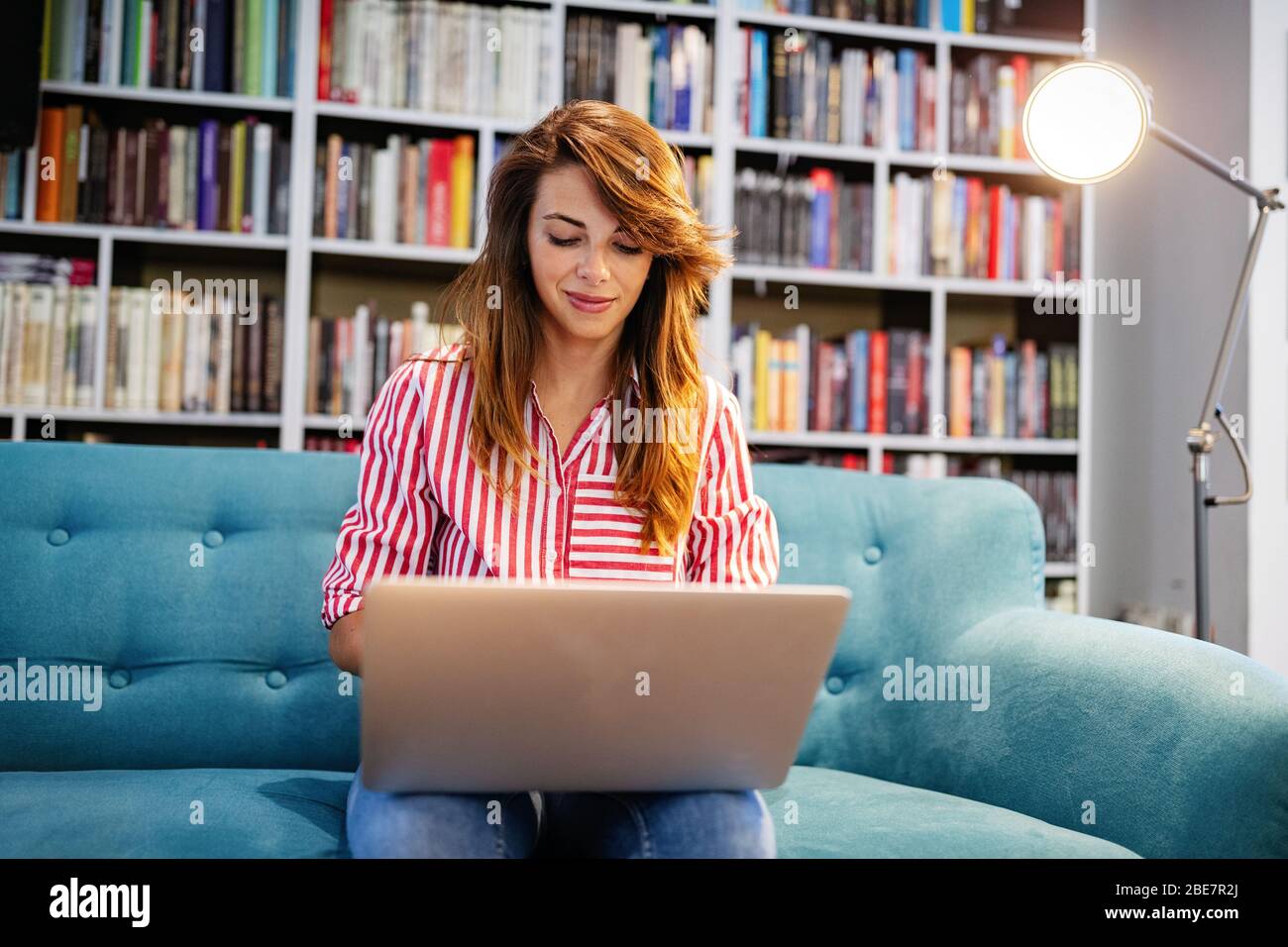 Portrait of happy student woman working on laptop Stock Photo