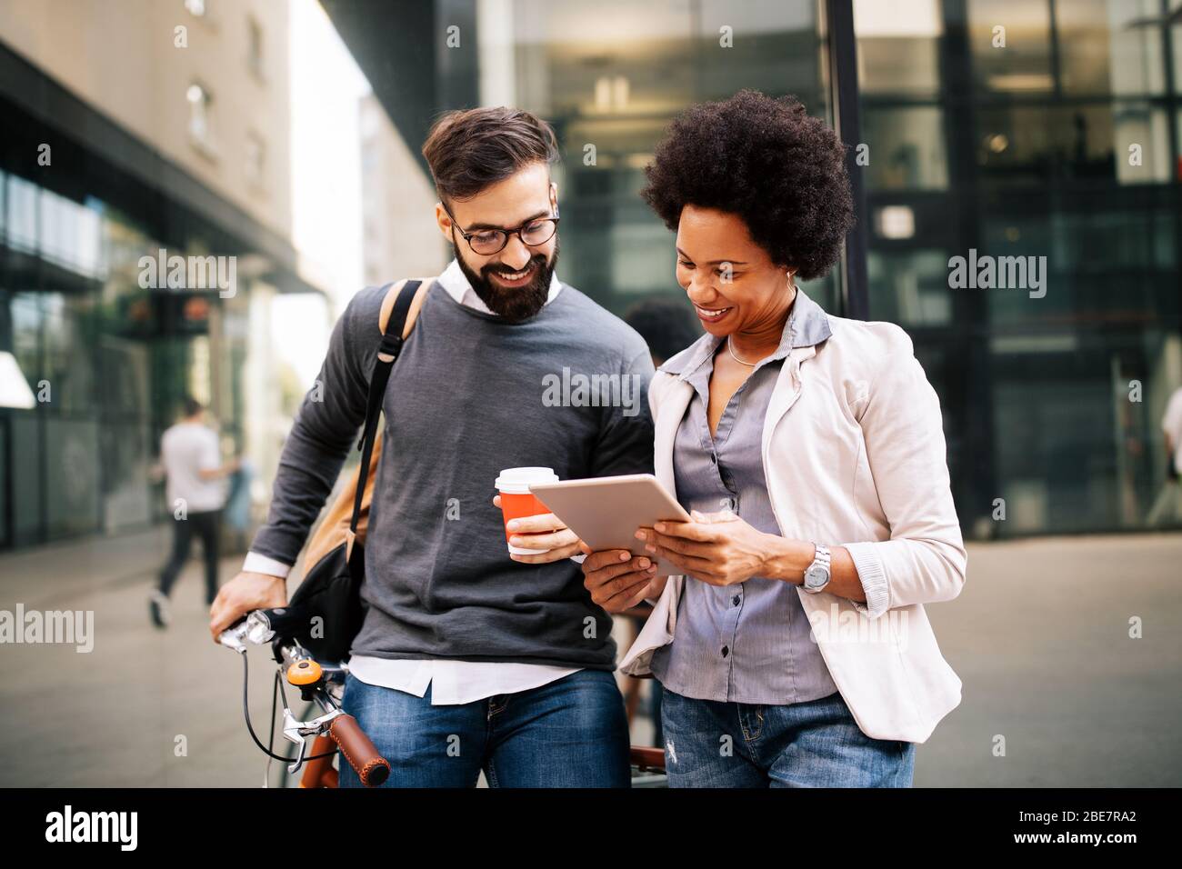 Business people discussing and smiling while walking together outdoor Stock Photo