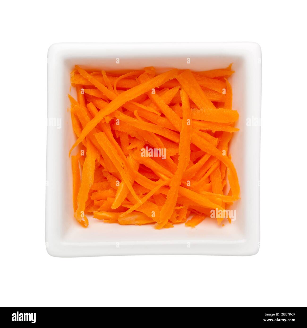 Shreds of carrot in a square bowl isolated on white background Stock Photo
