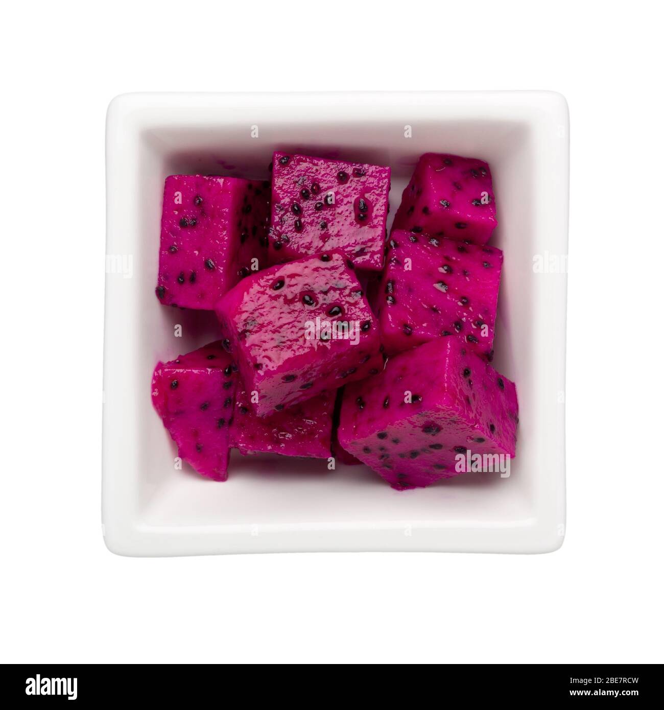 Pieces of red dragonfruit in a square bowl isolated on white background; Stock Photo