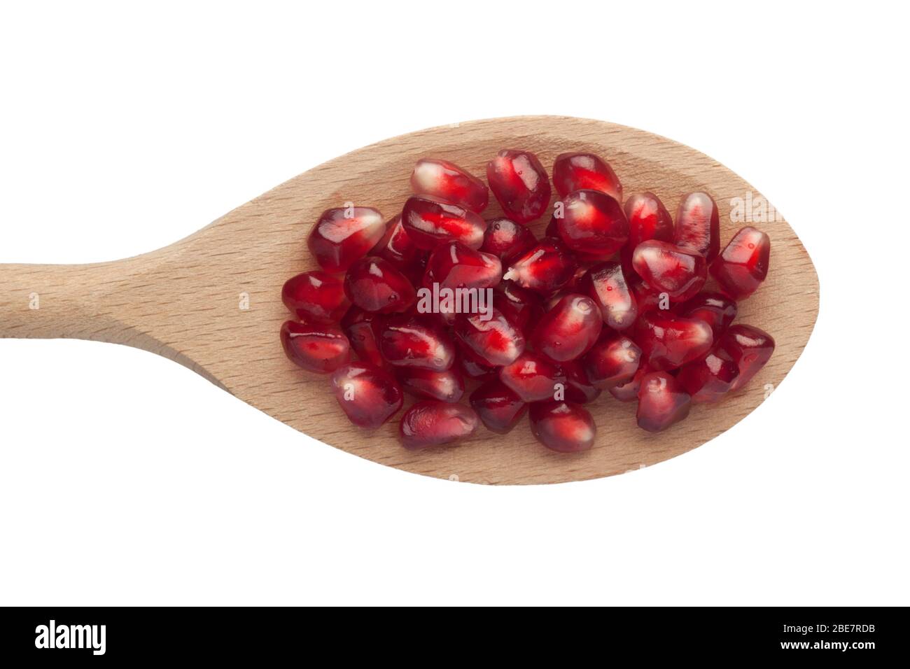 Pomegranate arils in a wooden spoon isolated on white background Stock Photo
