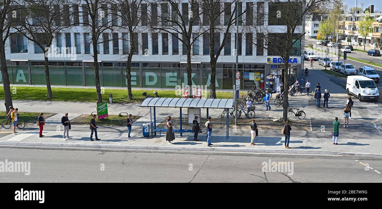 Queue in front of supermarket, people keep distance because of Corona, Munich, Upper Bavaria, Bavaria, Germany Stock Photo