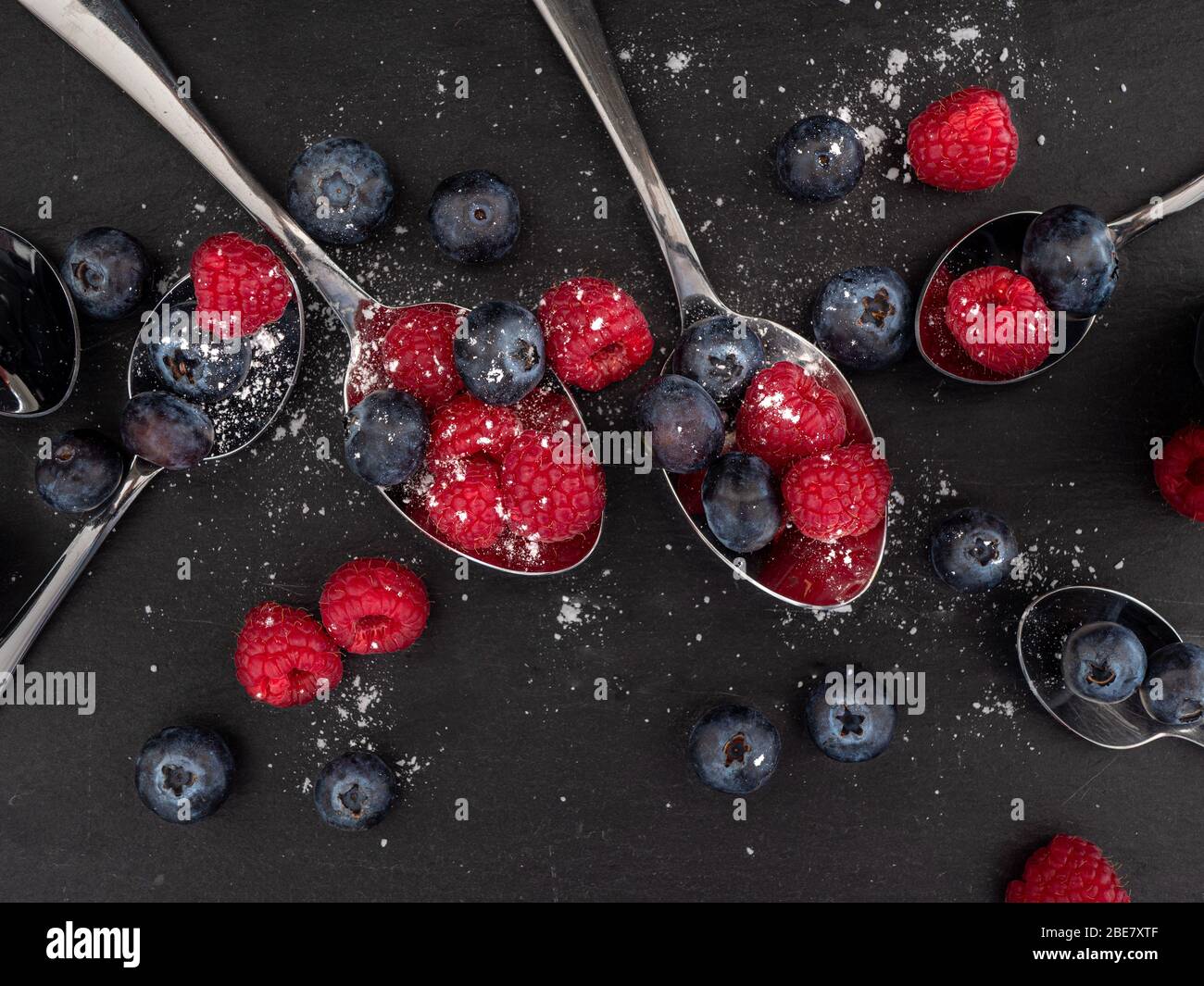 Looking down on a flat lat of raspberries and blueberries on a slate background Stock Photo