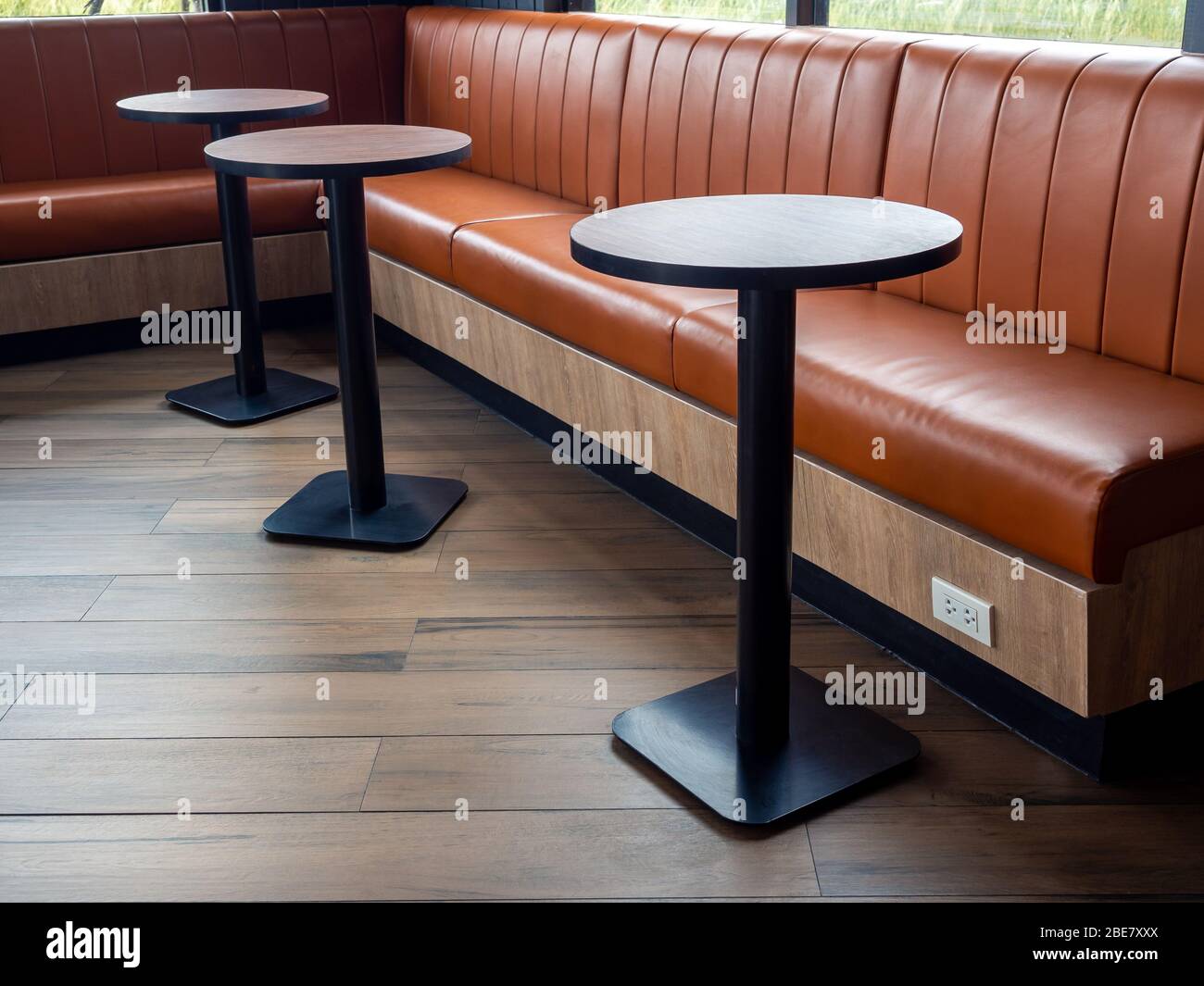 Furniture Decoration In Cafe Retro Style Empty Round Wood Table Bars And Orange Long Leather Sofa On Wood Floor With Natural Daylight Stock Photo Alamy