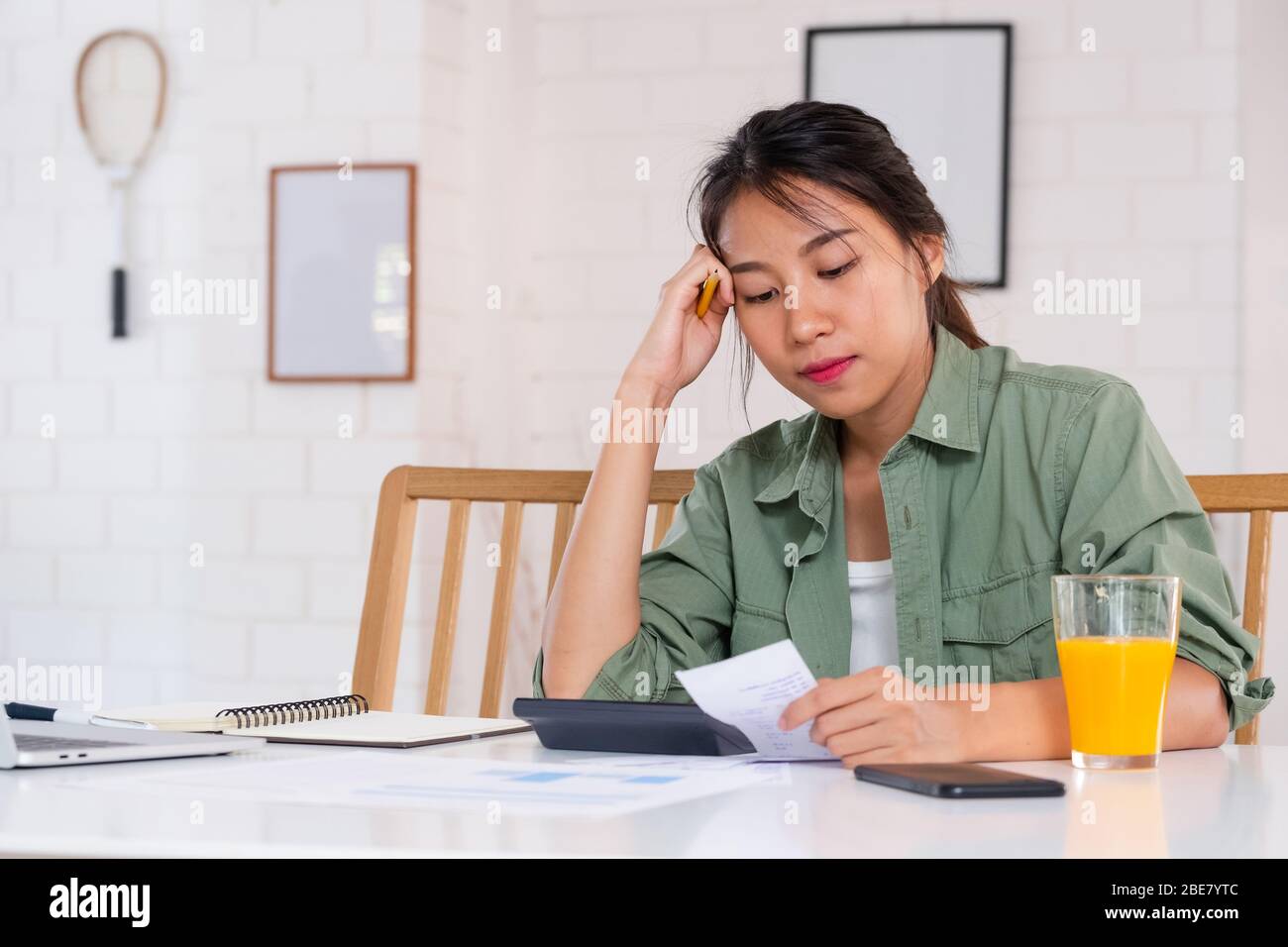 Stressed Asian woman serious and argument when calculate home financial bill budget on table in kitchen at new house Stock Photo