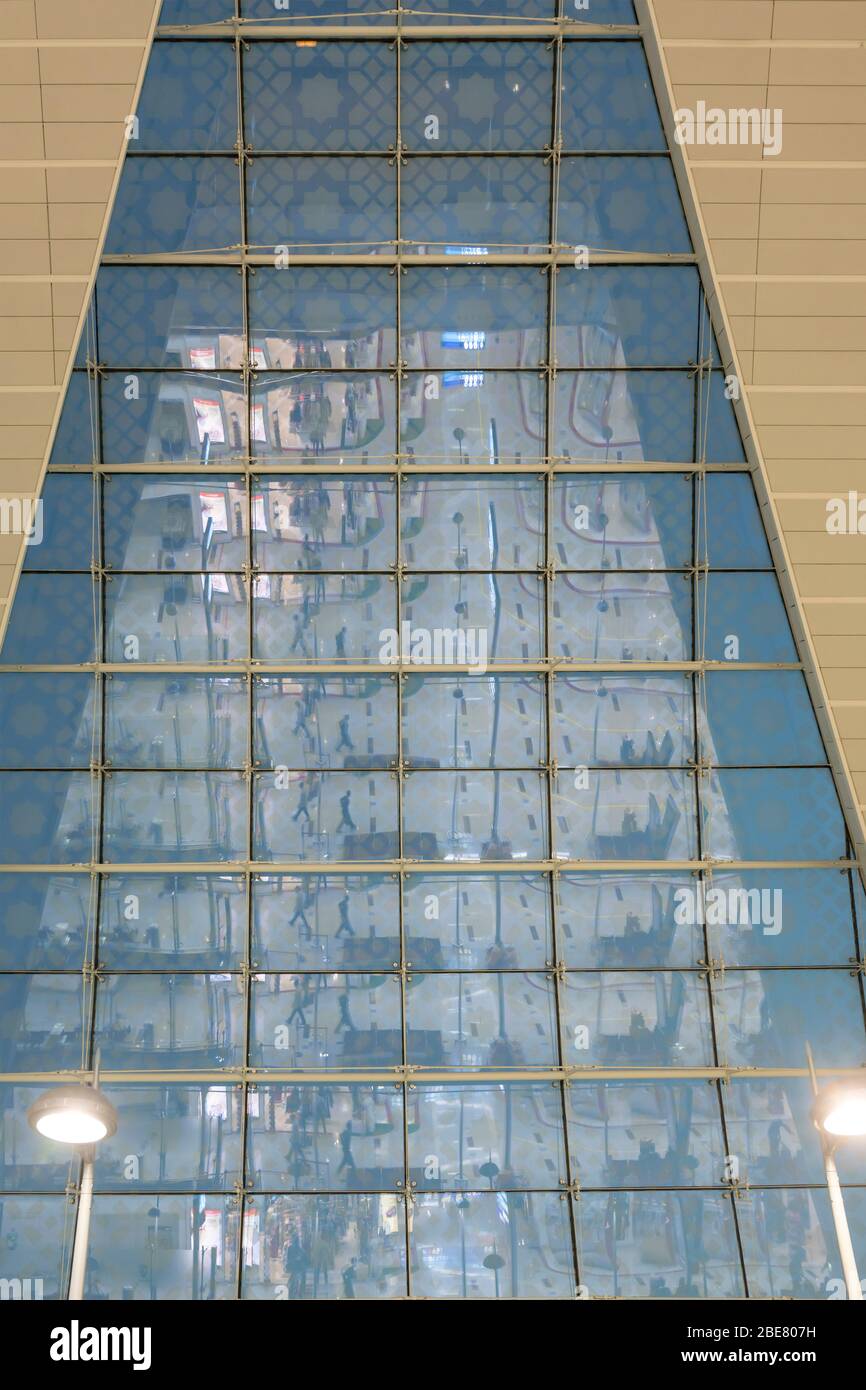 DUBAI, UAE - December 04 2019: indoor view with night life reflecting on tall windows at international airport transit area, shot in artificial light Stock Photo