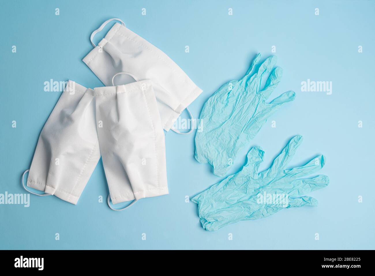 protective masks and disposable latex gloves on a colored surface Stock Photo