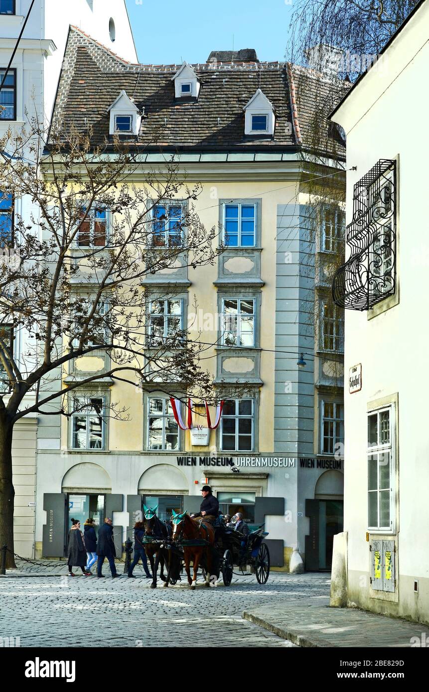 Vienna, Austria - March 27th 2016: Unidentified people and coachman in horse drawn coach named Fiaker, traditional kind of transport for sightseeing i Stock Photo