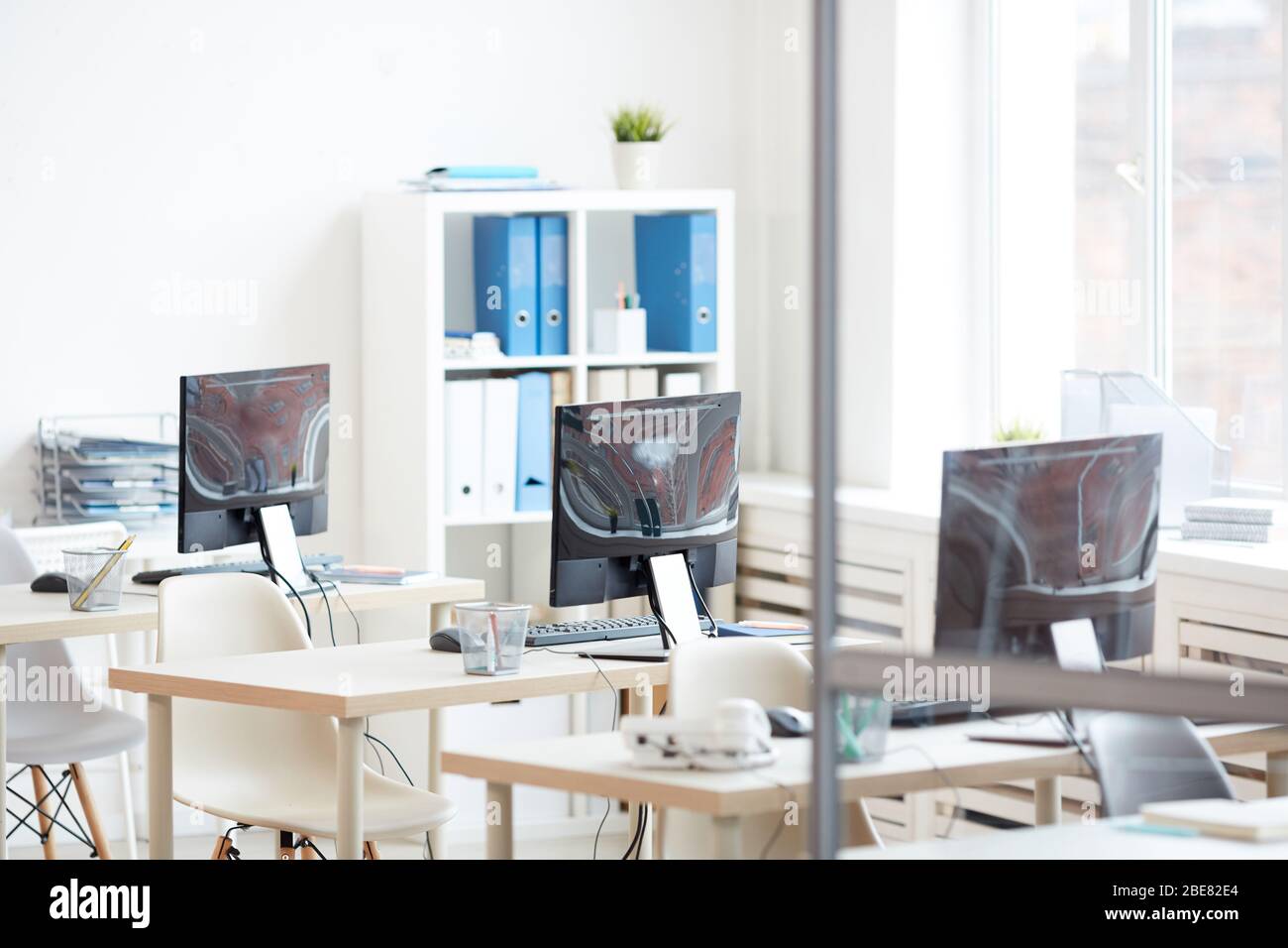 Background image of empty office desks in row set shot from behind