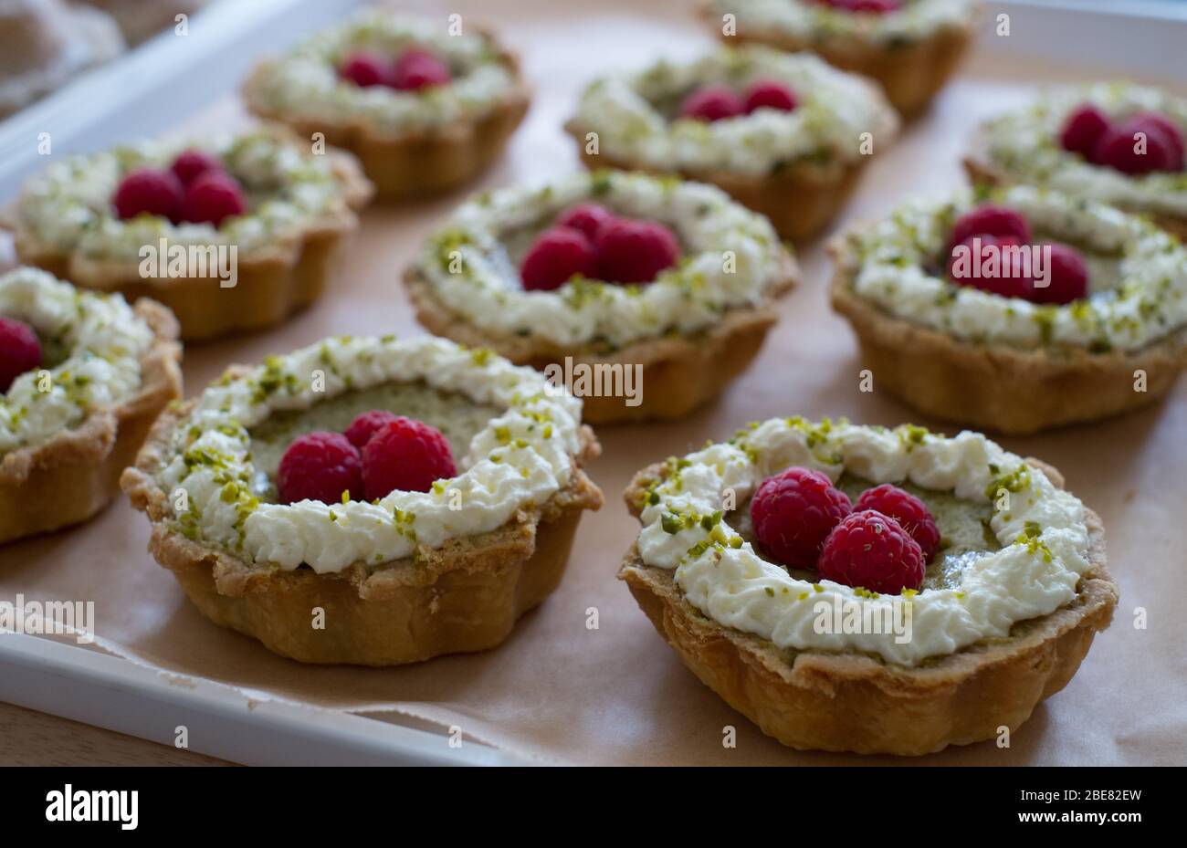 Raspberry and pistachio frangipane tarts, made by Scotland-based artisan baker Louise Paterson Stock Photo