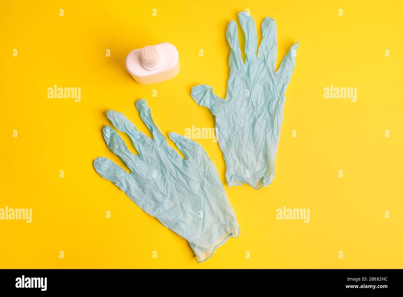 disposable latex gloves and disinfectant on a colored surface Stock Photo