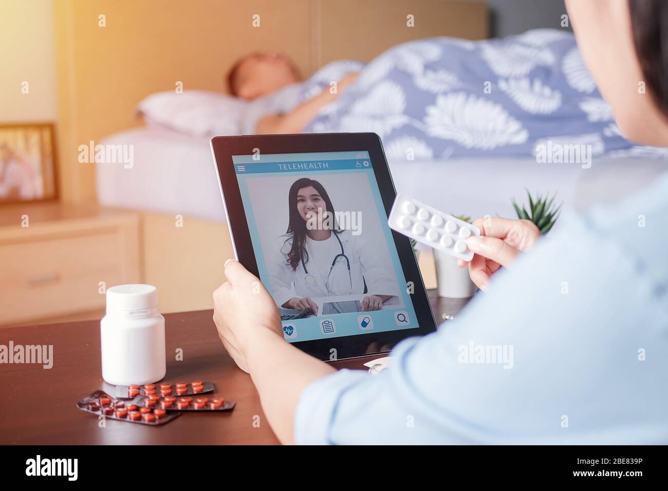 Patient's relatives use video conference, make online consultation with doctor on mobile application, ask doctor about illness , medication via video Stock Photo