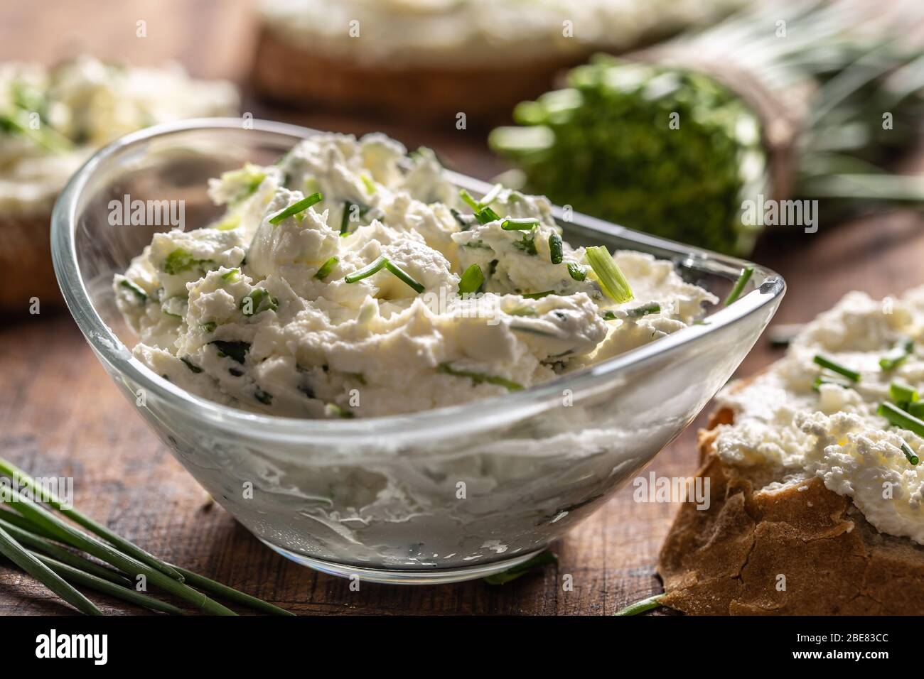 A bowl of homemade cream cheese spread with chopped chives surrounded ...