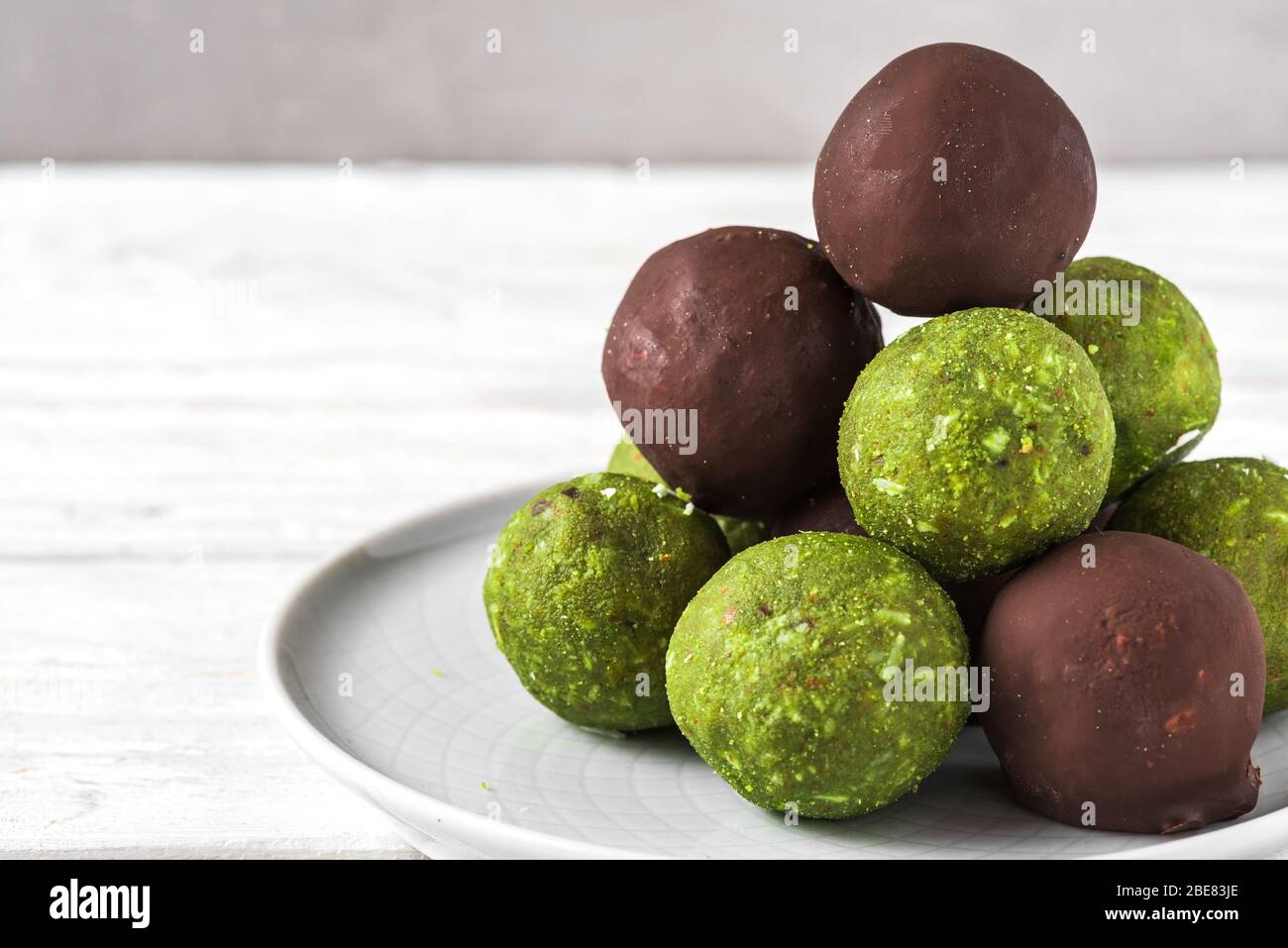 Green matcha energy balls with matcha balls in chocolate glaze. Healthy vegan food dessert. close up Stock Photo