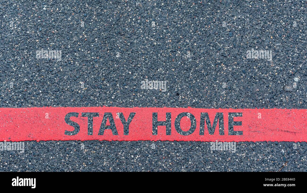 Restriction Stay top View of the asphalt road with red line and text STAY HOME ...