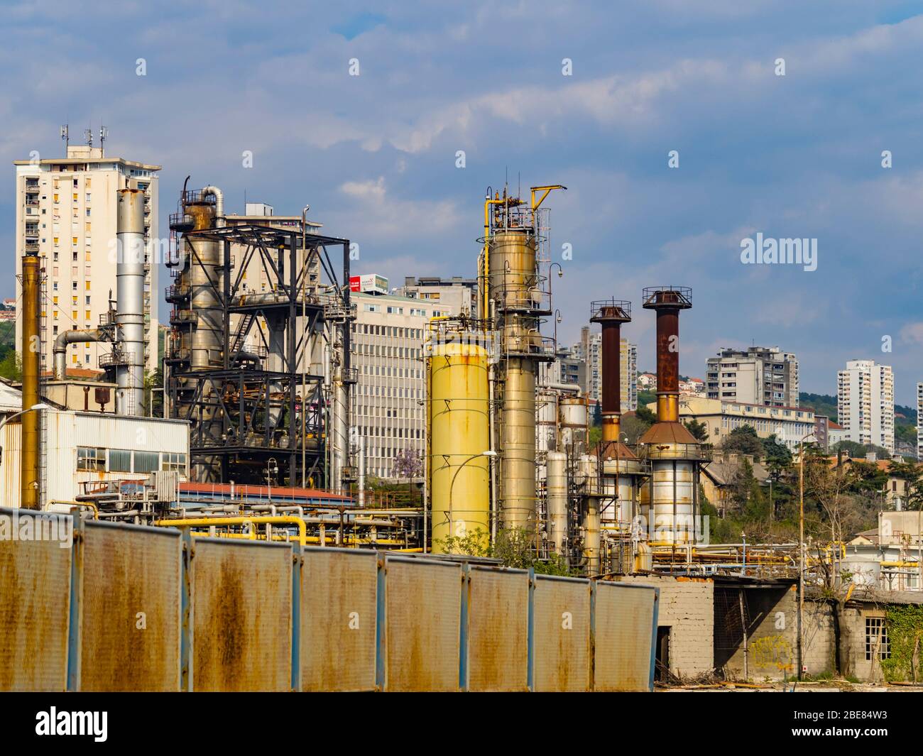 INA Mlaka largely abandoned elderly oil-refinery facility technology before town buildings skyscrapers in Rijeka Croatia Stock Photo