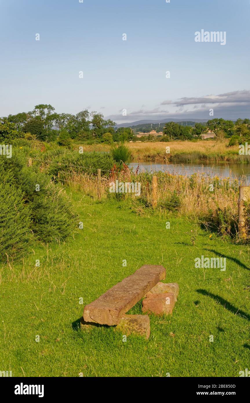 A small Stone Bench on the Footpath from the Montrose Basin along the River South Esk on a sunny morning in August. Stock Photo