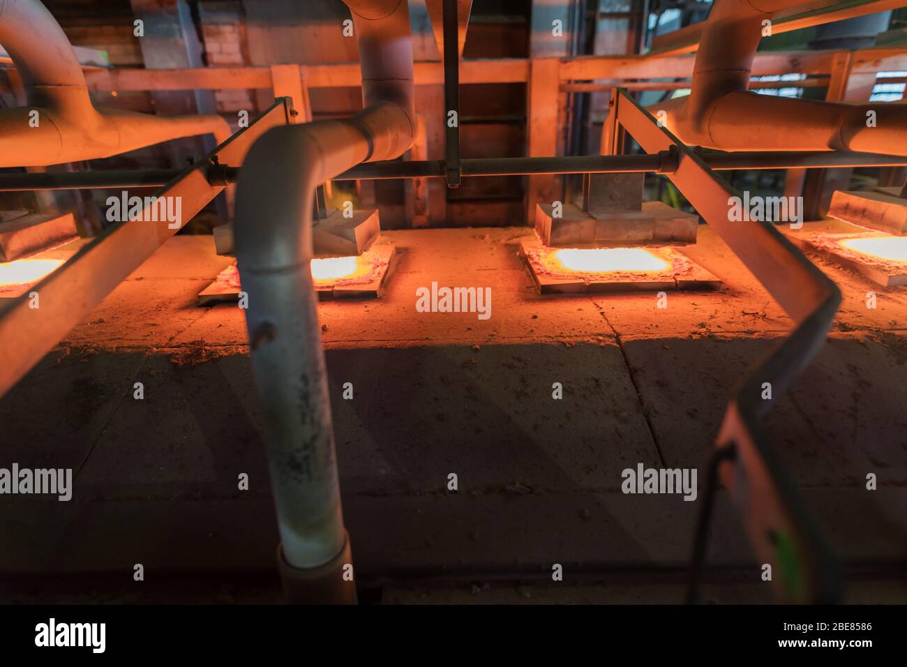 Glassworks. Glass industry. Burning blanks of glass bottles in an