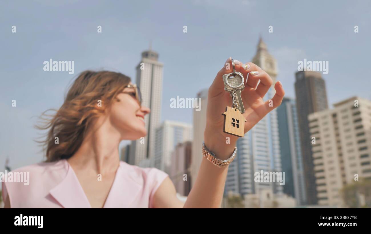 The concept of buying an apartment. Girl holds the keys to a new house ...