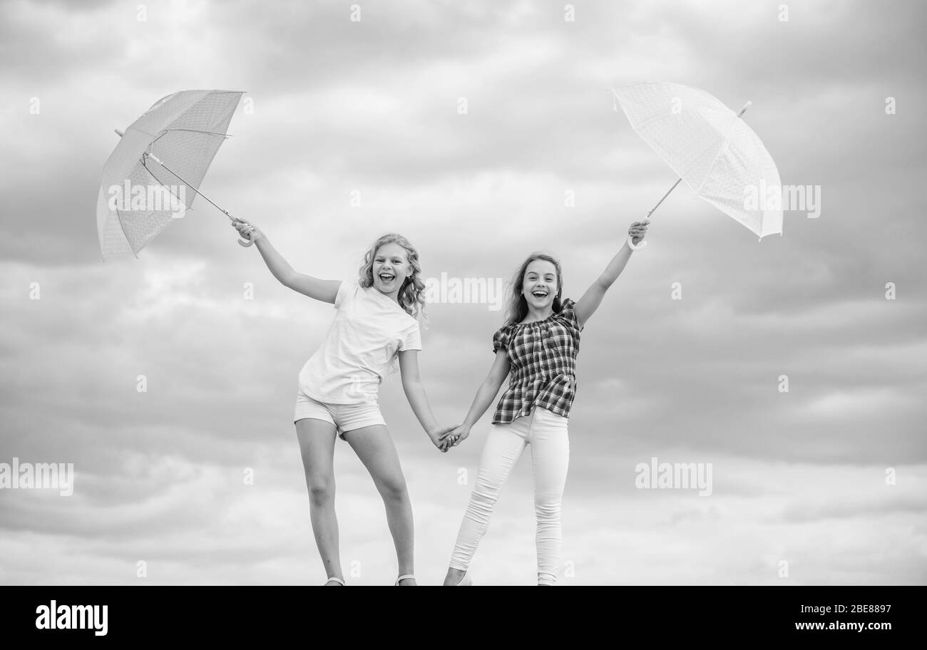 Ready for new adventures. protected at autumn day. happy small girls with umbrella. positive and bright mood. best friends. school time. autumn season. rainy weather forecast. fall kid fashion. Stock Photo