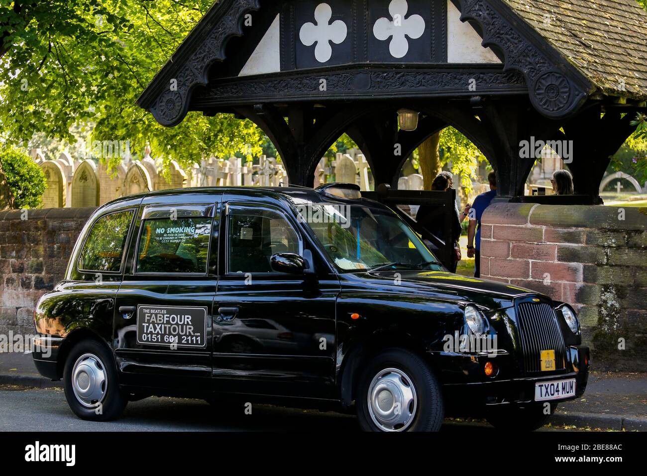 Black Taxi Tour parked in front of St Peters Church in Woolton Village Liverpool, where John Lennon and Paul McCartney first played together Stock Photo