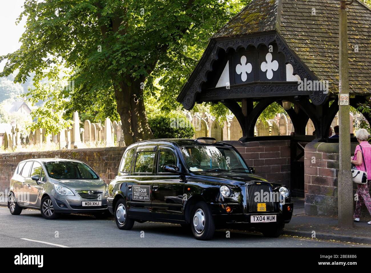 Black Taxi Tour parked in front of St Peters Church in Woolton Village Liverpool, where John Lennon and Paul McCartney first played together Stock Photo