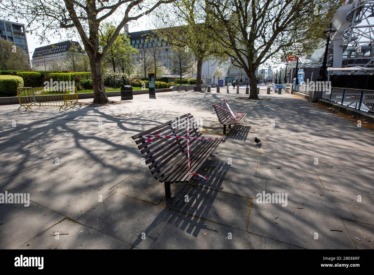 Taped off park benches sit empty along the Southbank of London, prohibiting tourists sitting on them during the coronavirus lockdown, England, UK Stock Photo