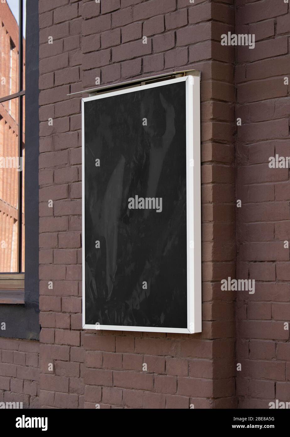 Blank black glass rectangular poster mock up brick wall mounted Stock Photo