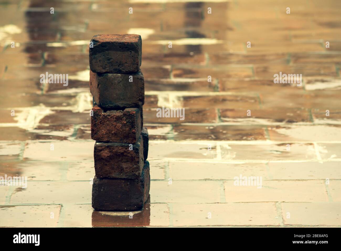 Old bricks used in construction stacked over one another on wet floor