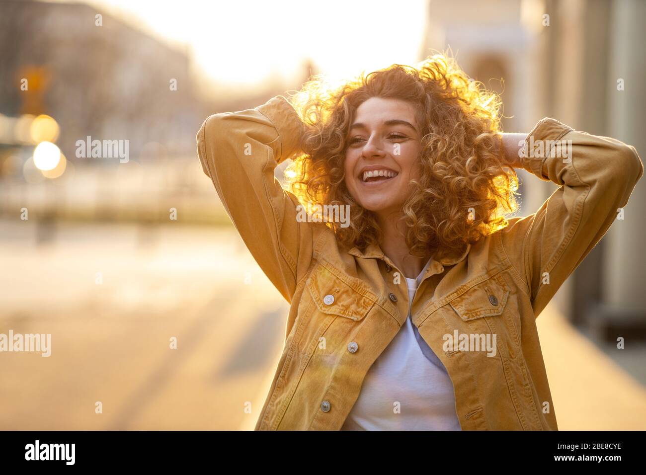 Portrait of young woman with curly hair in the city Stock Photo
