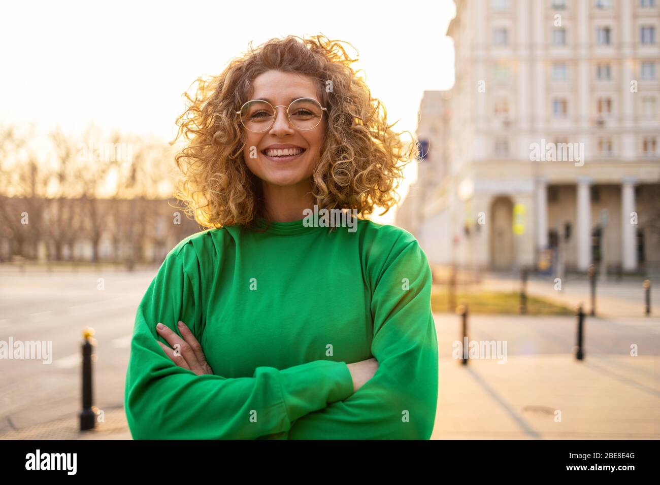 Portrait of young woman with curly hair in the city Stock Photo - Alamy