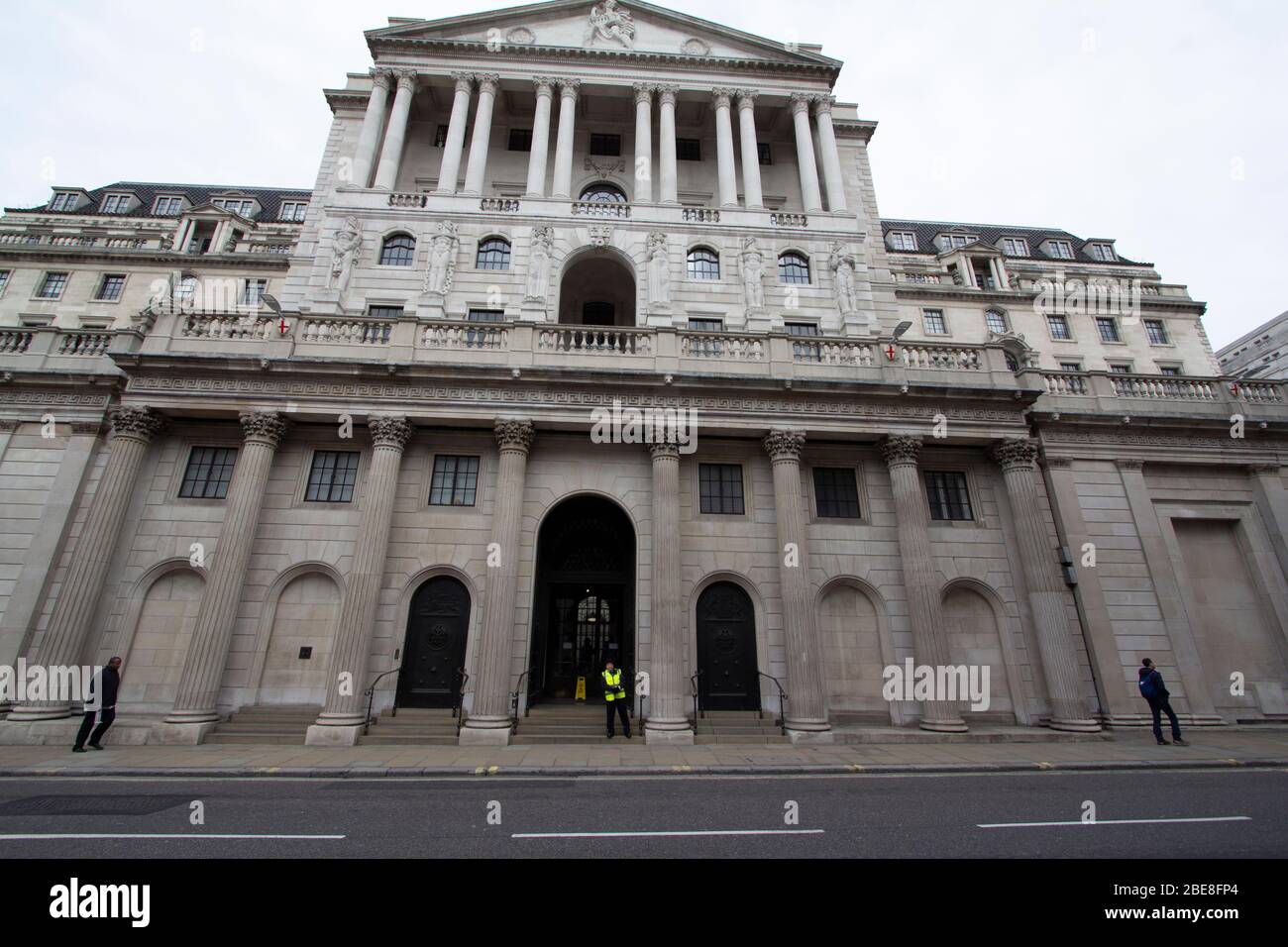 Security guard stands outside the Bank of England in the City of London, the streets where empty due to the Coronavirus Covid 19 lockdown. Stock Photo